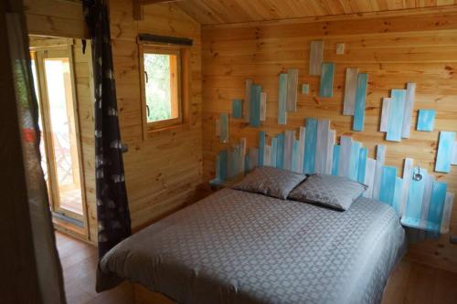 WahlbachChalet au Natur'Heil Nature-Spa-Gourmandise的小木屋内一间卧室,配有一张床