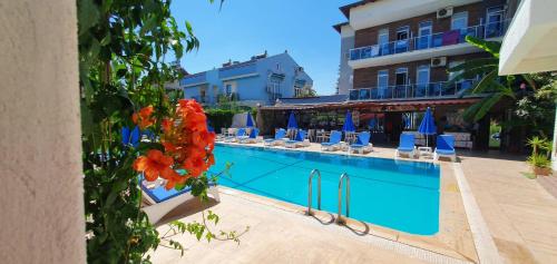 费特希耶garden alis hotel的一个带椅子的游泳池和一间酒店