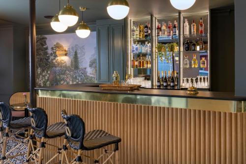 巴黎Hotel Fior d'Aliza的吧台前有两把蓝色凳子的酒吧