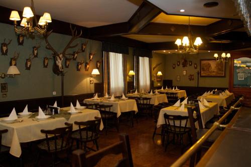 萨尔瓦尔Platán Hotel的用餐室配有桌椅和白色桌布