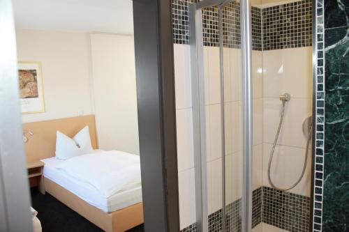 美因河畔法兰克福Hotel Hübler的一间卧室设有淋浴和一张床