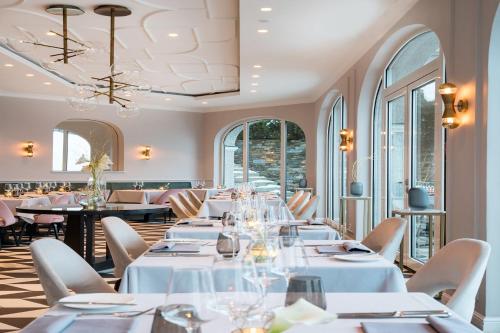 泰根塞达斯泰根塞酒店的餐厅设有白色的桌椅和窗户。