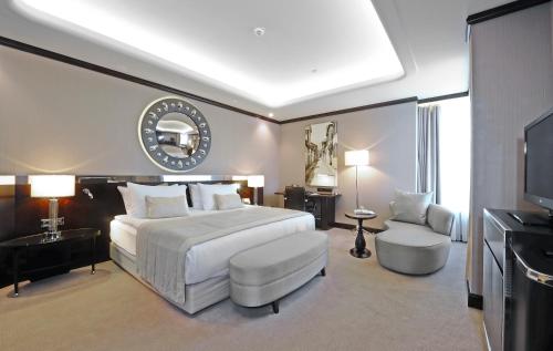 伯萨布尔萨会议温泉皇冠酒店 的卧室配有一张白色大床和电视。