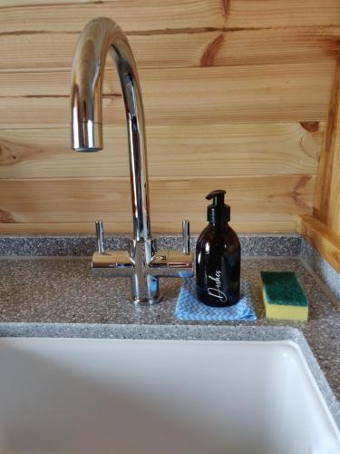 艾茅斯Braeview Glamping的厨房水槽旁设有带肥皂饮水机的水槽