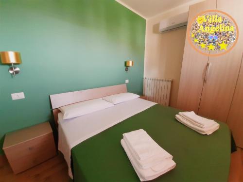 特罗佩阿Residenza Villa Angelina Tropea的卧室配有绿色和白色的床,提供毛巾