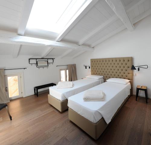 帕尔马Opera 11 r&b的配有白色墙壁和木地板的客房内的两张床