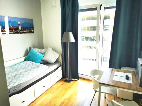 慕尼黑Top-Apartment a.d. Messe的一间卧室配有一张床、一张书桌和一个窗户。