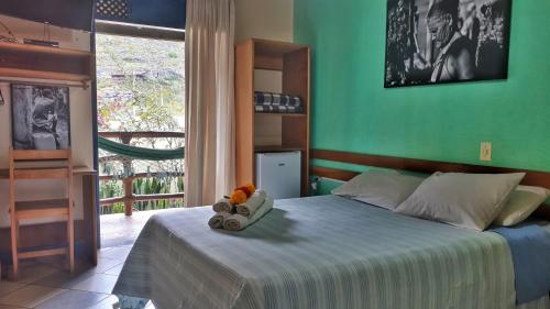 穆库热Pousada Recanto da Chapada的一间卧室配有一张带绿色墙壁的床