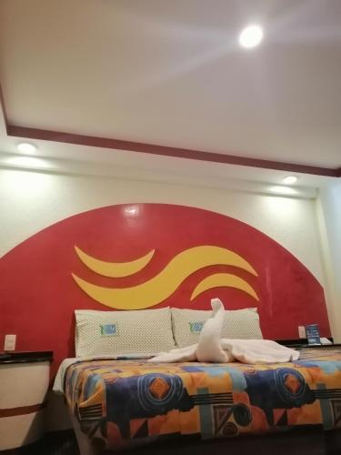 墨西哥城Hotel Atlántico的墙上有红色和黄色标志的床
