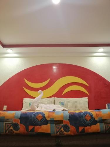 墨西哥城Hotel Atlántico的后面有红色和黄色标志的床
