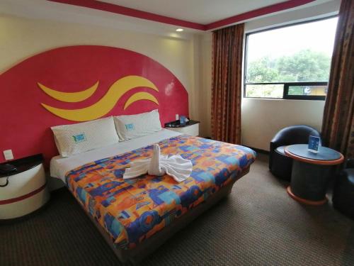 墨西哥城Hotel Atlántico的酒店客房,配有一张红色床头板的床