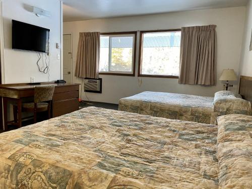 北贝特尔福德Hitching Post Motel的酒店客房配有两张床和一张书桌