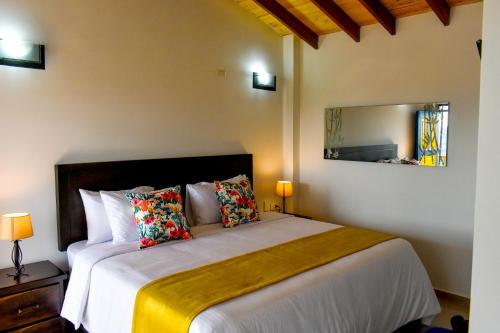 佩雷拉Ecohotel Guaduales Pereira的一间卧室配有一张大床和镜子