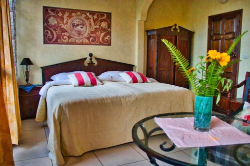 圣佩德罗拉拉古纳Casa Lobo Bungalows的一间卧室配有一张床和一张花瓶桌子