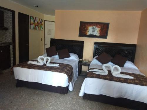 阿卡普尔科Suite en torres gemelas con vista al mar的酒店客房,配有两张带白色毛巾的床