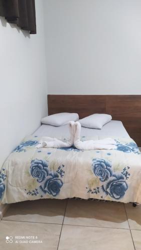 阿帕雷西达Pousada Quarto com tv,ar,frigobar,wifi e garagem的一张带蓝色和白色床单及枕头的床