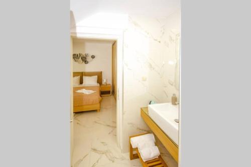 基萨莫斯Mare Monte Luxury Apartment的一间带水槽和镜子的浴室以及一张床