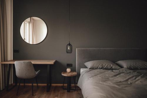 Cornedo all'IsarcoPitzner - Winery & Suites的一间卧室配有一张床、一张桌子和一面镜子