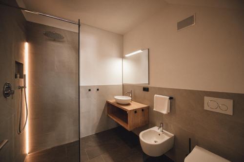Cornedo all'IsarcoPitzner - Winery & Suites的一间带水槽、卫生间和淋浴的浴室