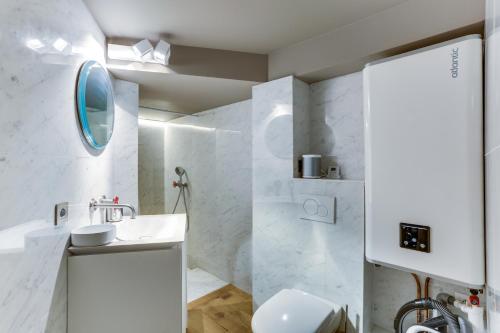 巴黎Bail Mobilité Appartement, Place Vendome, Opera的白色的浴室设有水槽和镜子
