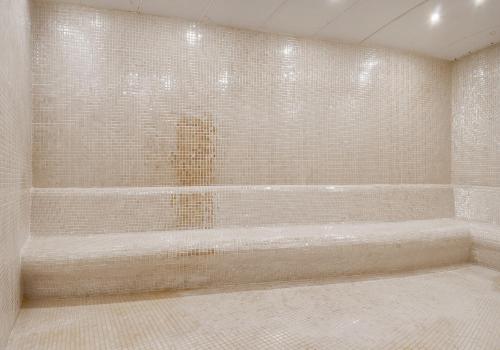 库萨达斯TNR Otel & Spa的带浴缸的浴室和瓷砖墙壁