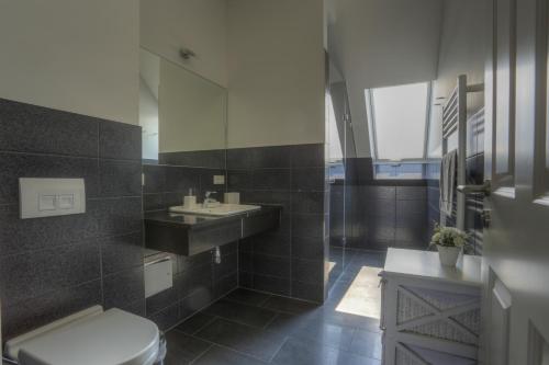 伯尔格伦德-雷特维施Villa Namenlos的一间带卫生间、水槽和镜子的浴室