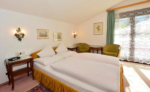 蒂罗尔-泽费尔德Haus Orplid的一间卧室配有一张床、一张桌子和一个窗户。