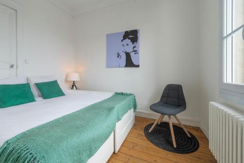 昂热Appartement Coeur de Ville rue Saint-Laud的一间卧室配有一张床和一把椅子