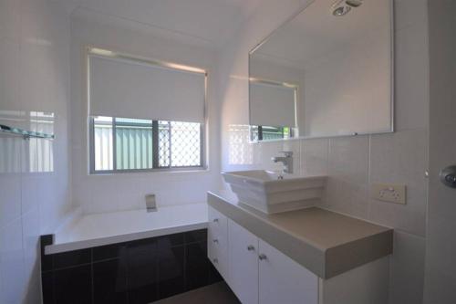 班达伯格Home away from home - Modern luxury in central Bundaberg的白色的浴室设有水槽和镜子