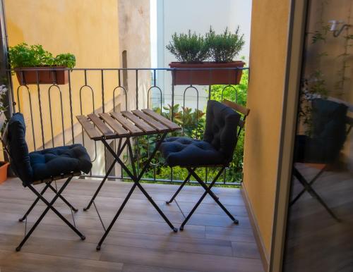 陶尔米纳TaoMau - Duomo Square的阳台配有2把椅子和1张桌子