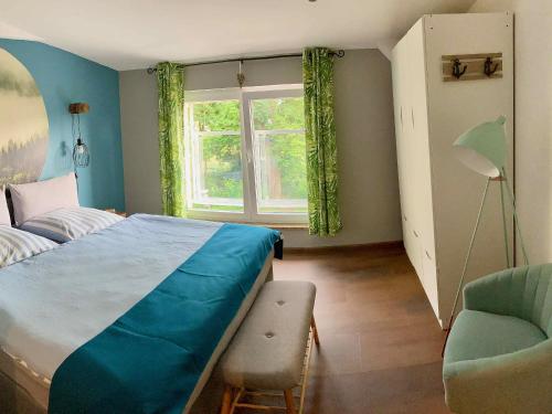 FriedrichswaldeFerienwohnungen Zur Biberburg的卧室配有床、椅子和窗户。