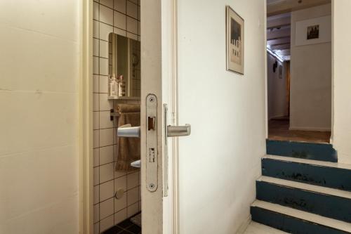 阿姆斯特丹B&B 1971 Hazenstraat - Shared Bathroom的通往带楼梯的浴室的门