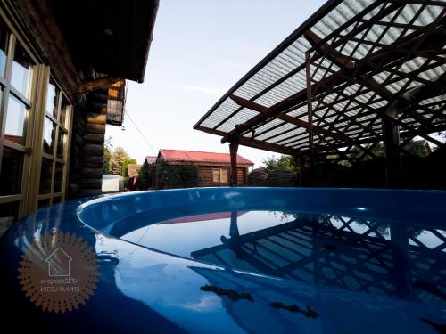 帕维洛斯塔Guest house Zvejnieksēta的屋顶房子里的一个大型蓝色游泳池