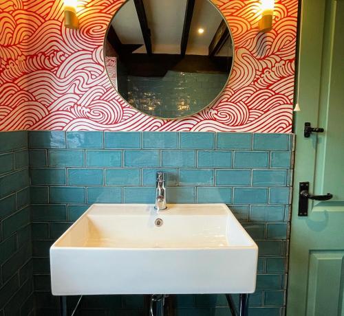 费克纳姆Sculthorpe Mill的浴室设有白色水槽和镜子