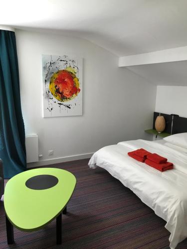 旺特龙La maison de Cécile的一间卧室配有床、绿桌和绘画