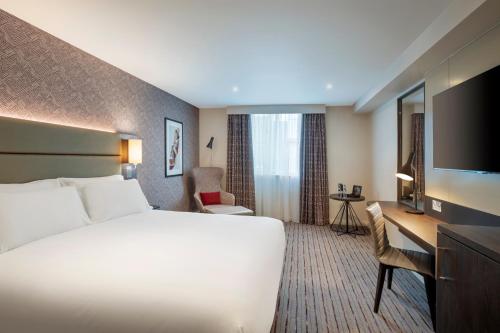 切斯特Leonardo Hotel Chester的酒店客房配有一张床、一张书桌和一台电视。