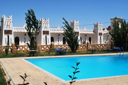Aguelmous蒂姆尼宫酒店的一座带游泳池的度假村,位于一座建筑前