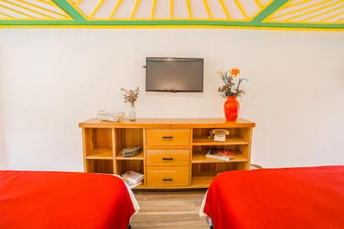 萨兰托Hotel Mirador de Boquia Salento的一间配备有电视的带两张床的房间