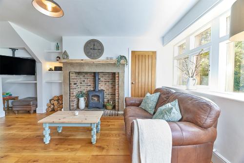 OvinghamHost & Stay - Waterleap Cottage的带沙发和壁炉的客厅