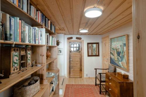 埃斯波Sirpa's Artistic Nuuksio Retreat with Heated Pool的一间设有木制书架的房间