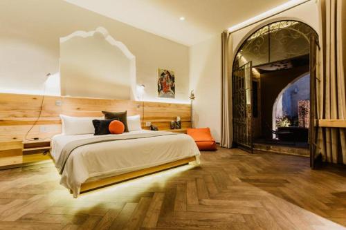克雷塔罗Tá Hotel de diseño的一间卧室设有一张大床和一个拱形门廊