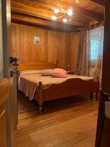 艾马维尔Val di Cogne Il Grand Nomenon的卧室配有一张床铺,位于带木墙的房间内