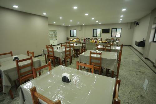 伊塔佩米林河畔卡舒埃鲁Hotel Diamantte的一间设有白色桌椅的用餐室和一间设有
