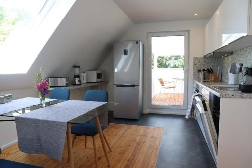 加格瑙Ferienwohnung Habitat的厨房配有冰箱和桌椅
