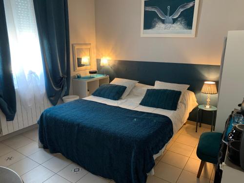 纳博讷La Turenne的一间卧室配有一张带蓝色毯子的大床