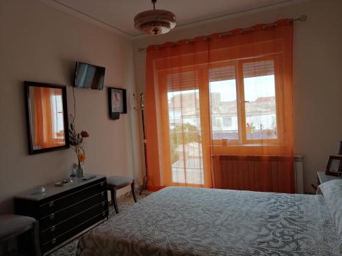 TobarraAlojamiento Rural的一间卧室配有一张床、一个梳妆台和一扇窗户。