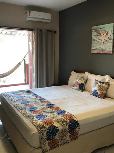 乌巴图巴Pousada Vista Dell Mar的卧室内的一张大床,设有窗户