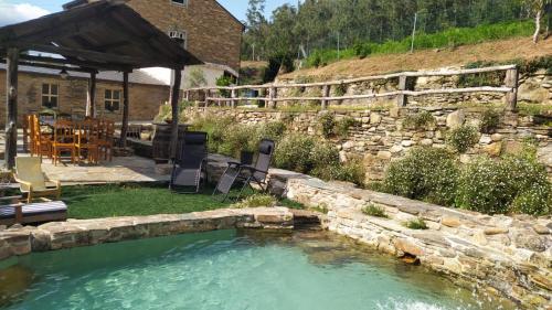 蒙多涅多A Casa das Augas的一座带石墙的庭院内的游泳池