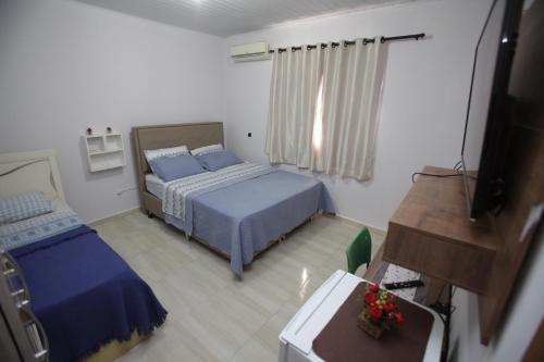 伊瓜苏Cantinho da Sônia的一间卧室配有两张床和电视。