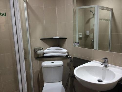 新山海景大酒店的一间带卫生间、水槽和镜子的浴室